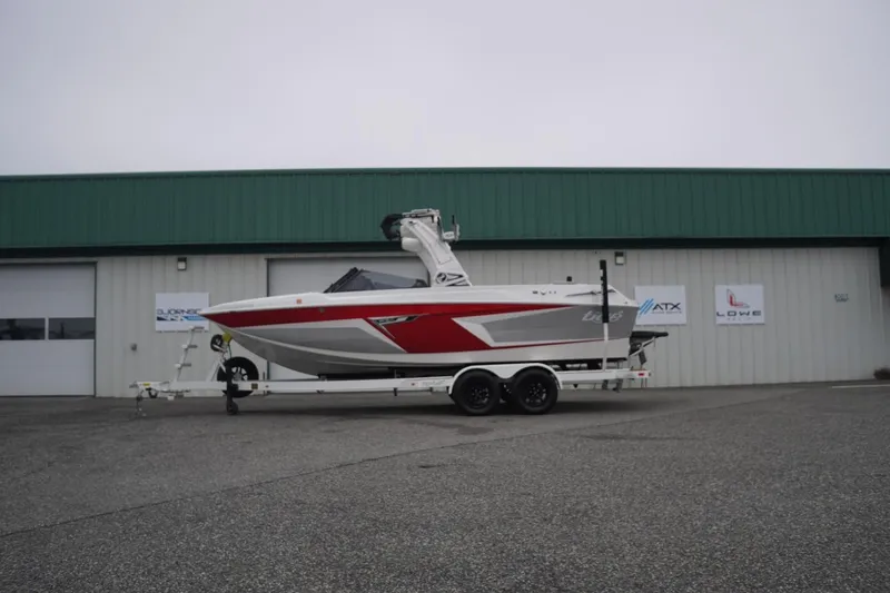 Slide: The Image of 2022 Tigé 22RZX boat on trailer outside a green-roofed building. - 65