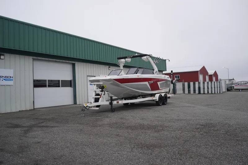 Slide: The Image of 2022 Tigé 22RZX boat on trailer outside a marine facility. - 67