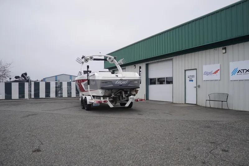 Slide: The Image of 2022 Tigé 22RZX boat parked outside a dealership with green metal siding. - 70