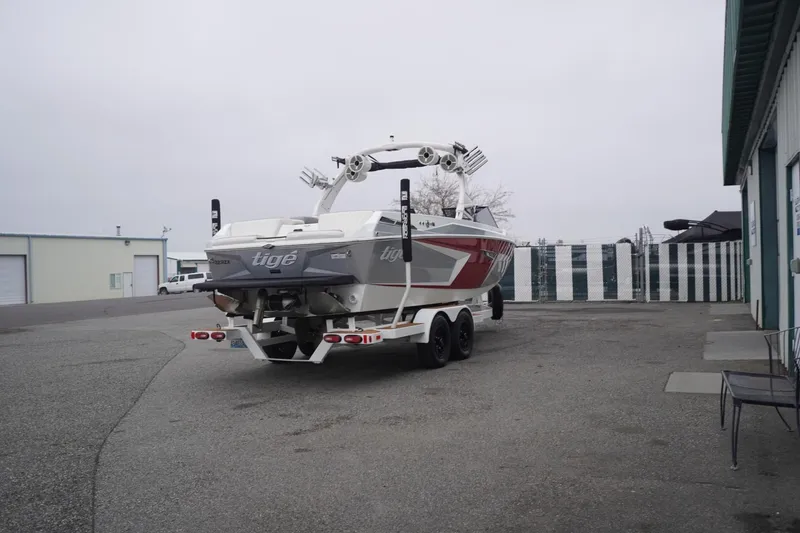 Slide: The Image of 2022 Tigé 22RZX boat on trailer in industrial area, overcast sky. - 71