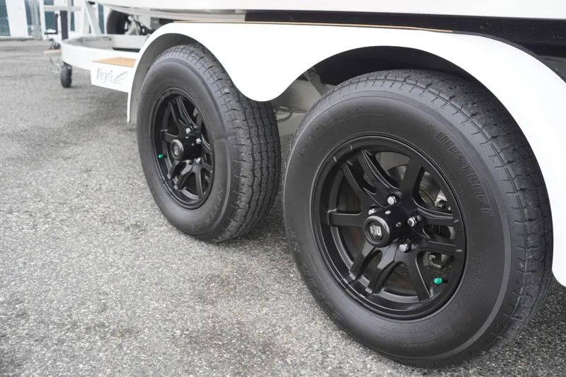 Slide: The Image of 2022 Tigé 22RZX trailer with black alloy wheels on a paved surface. - 75