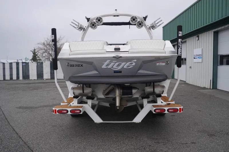 Slide: The Image of 2022 Tigé 22RZX boat rear view, parked outside a warehouse. - 9