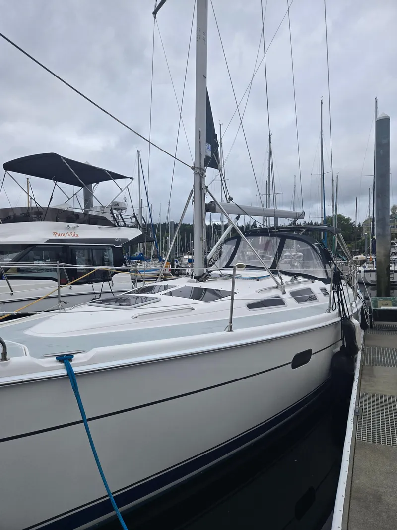 Slide: The Image of 2002 Hunter 356 sailboat docked at marina on a cloudy day. - 1
