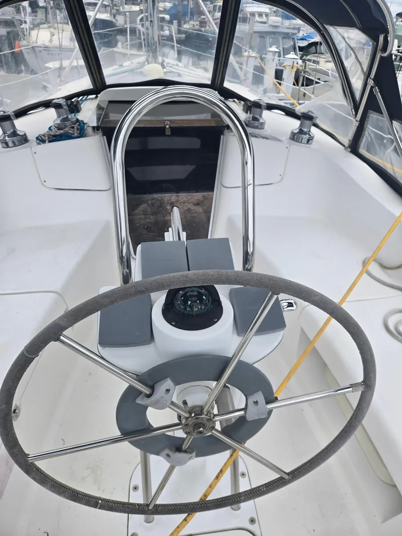 Slide: The Image of Steering wheel of a 2002 Hunter 356 sailboat in a marina setting. - 10