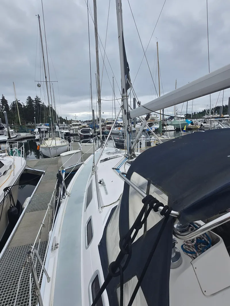 Slide: The Image of 2002 Hunter 356 sailboat docked in a busy marina under cloudy skies. - 11