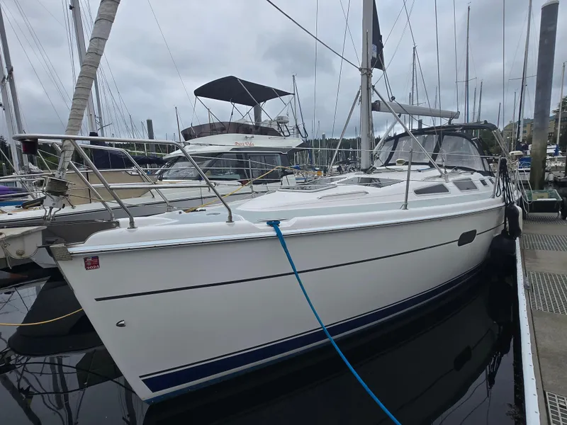 Slide: The Image of 2002 Hunter 356 sailboat docked at marina, overcast sky, surrounded by other boats. - 13