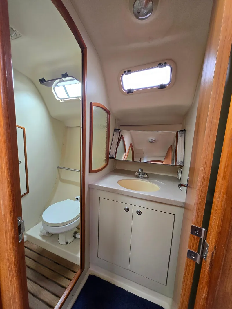 Slide: The Image of Bathroom interior of 2002 Hunter 356 sailboat with sink, toilet, and wooden accents. - 16