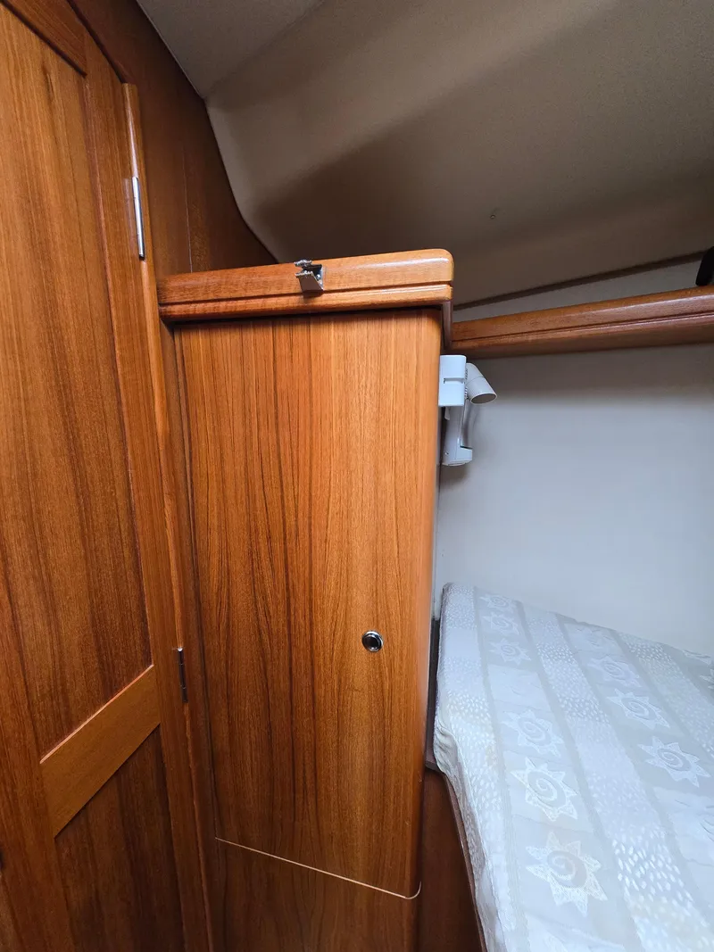Slide: The Image of Wooden interior of 2002 Hunter 356 sailboat cabin with bed and storage. - 19