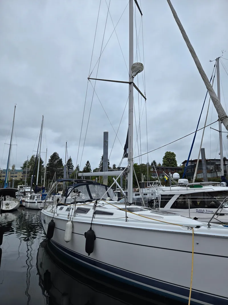 Slide: The Image of 2002 Hunter 356 sailboat docked in a marina, surrounded by other boats. - 2