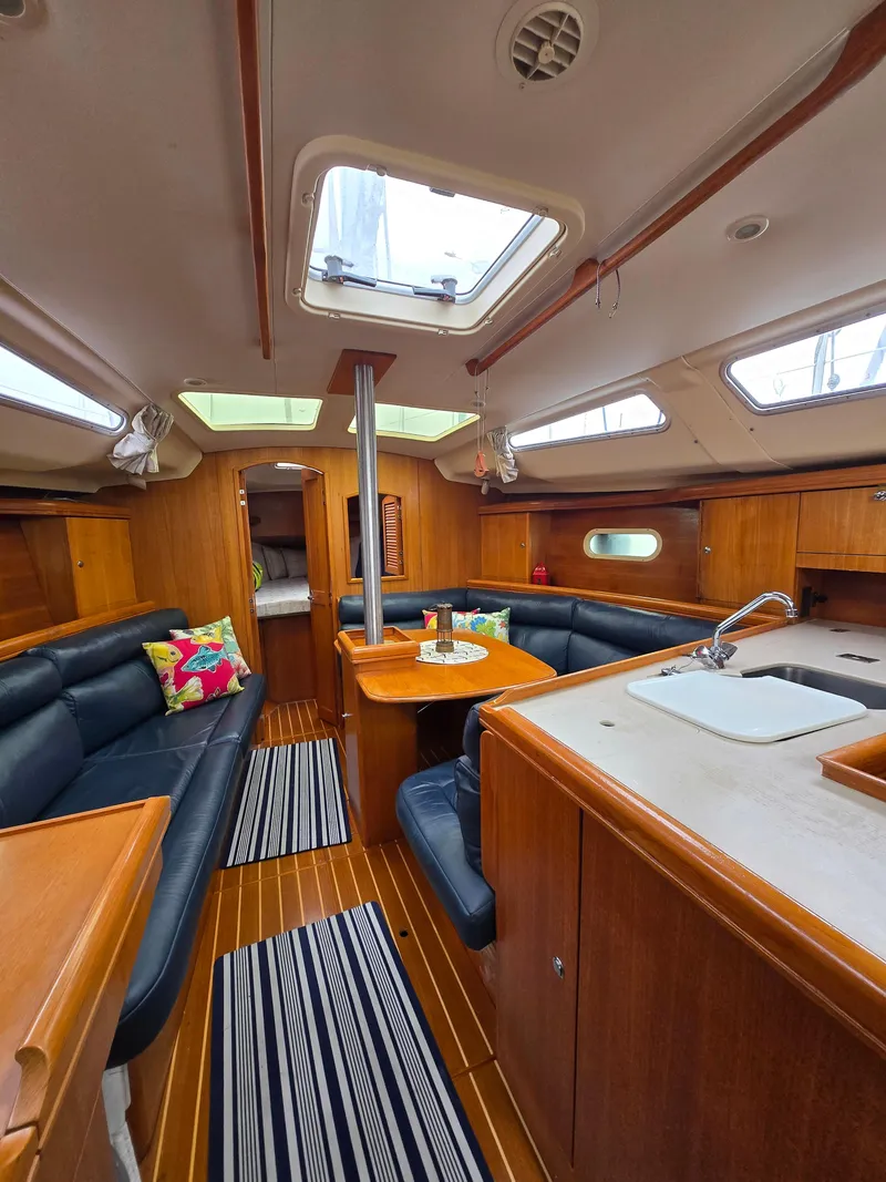 Slide: The Image of Interior of a 2002 Hunter 356 sailboat with wood finish and cozy seating area. - 20