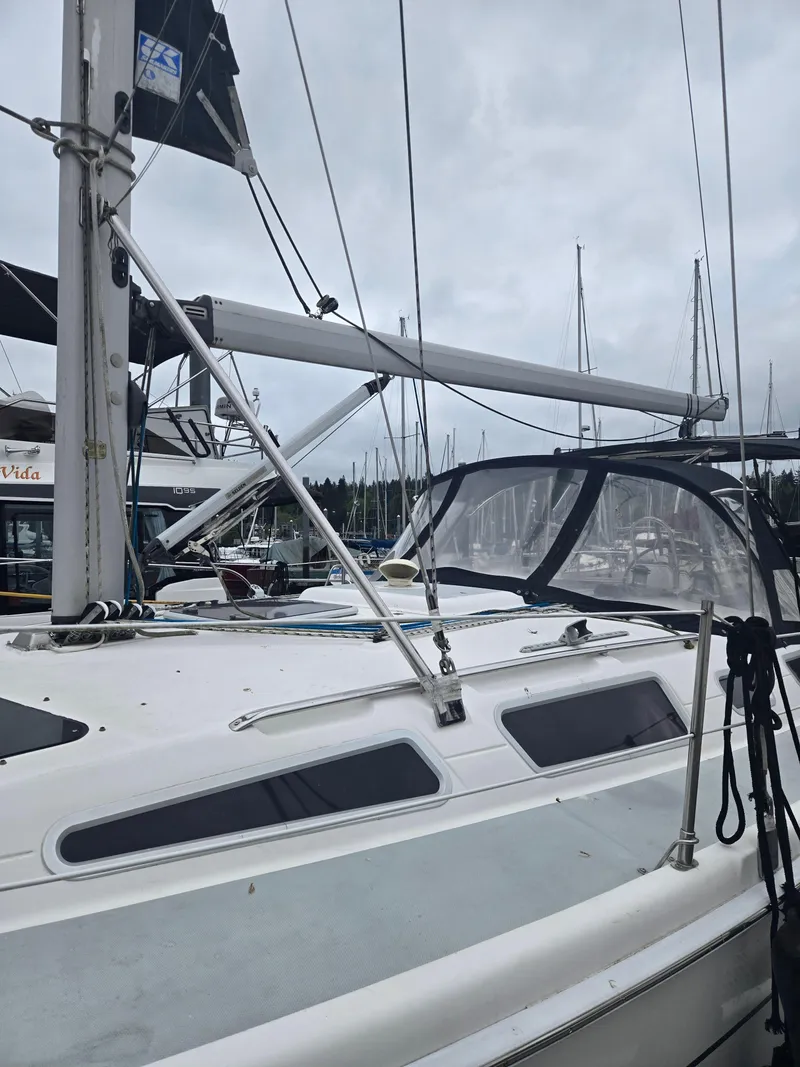 Slide: The Image of 2002 Hunter 356 sailboat docked in a marina, featuring a sleek design and overcast sky. - 4
