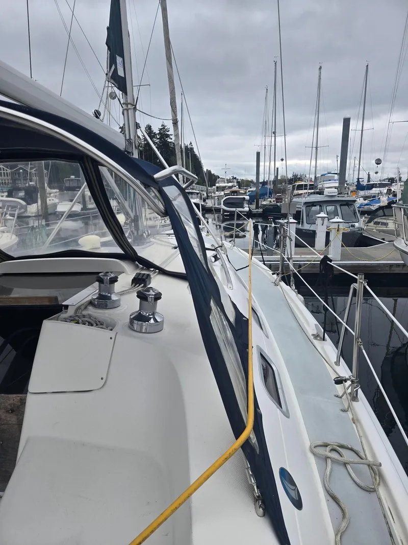 Slide: The Image of 2002 Hunter 356 sailboat docked in a marina, surrounded by other boats under cloudy skies. - 5