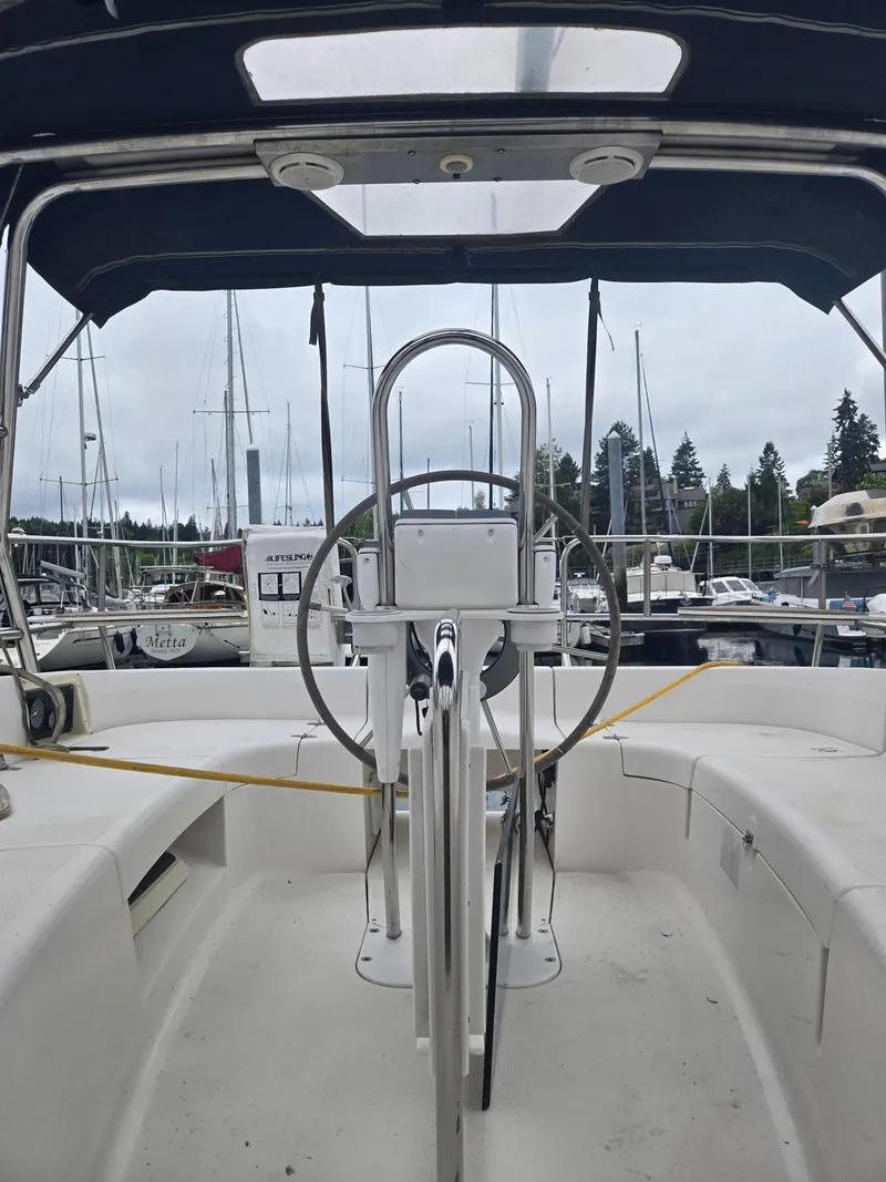Slide: The Image of 2002 Hunter 356 sailboat cockpit with steering wheel, docked in marina. - 6
