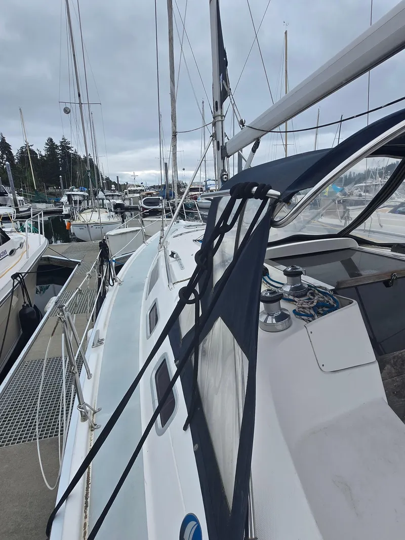 Slide: The Image of 2002 Hunter 356 sailboat docked at marina, overcast sky, view of deck and winches. - 8