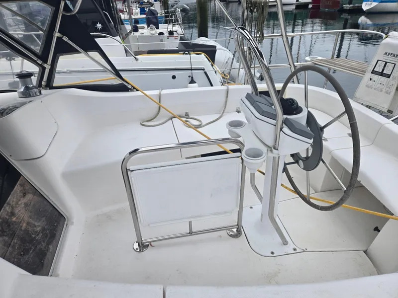 Slide: The Image of Cockpit of 2002 Hunter 356 sailboat with steering wheel and marina view. - 9