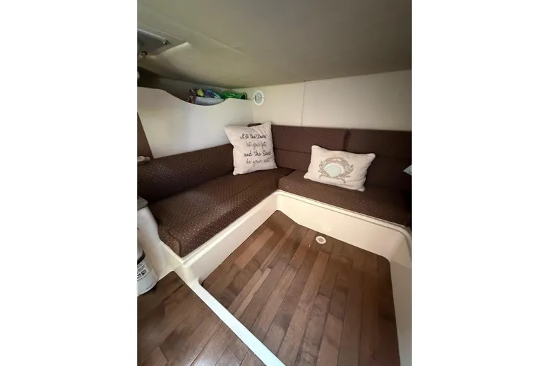 Slide: The Image of 2012 Boston Whaler 345 Conquest cabin interior with cozy seating and decorative pillows. - 10