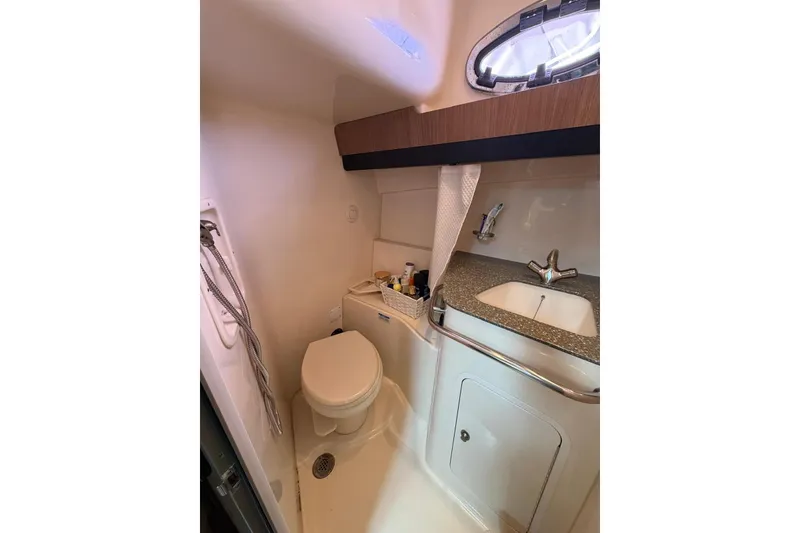 Slide: The Image of 2012 Boston Whaler 345 Conquest bathroom with toilet, sink, and showerhead. - 11