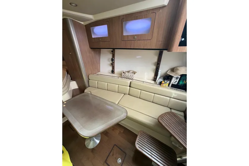 Slide: The Image of Interior of 2012 Boston Whaler 345 Conquest, featuring a cozy seating area and table. - 7