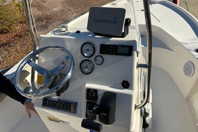 Slide: The Image of 2021 Key West 188 Bay Reef boat compartment with coiled hose and open lid. - 11