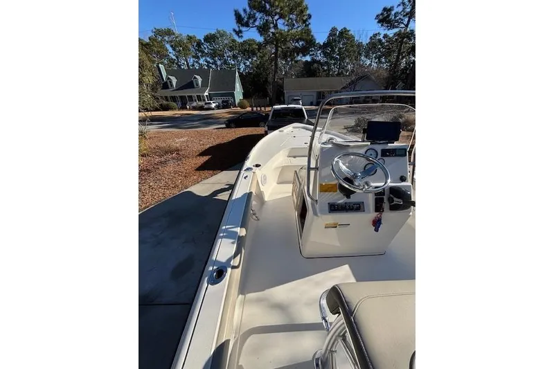 Slide: The Image of 2021 Key West 188 Bay Reef boat interior with seating and console, parked outdoors. - 14