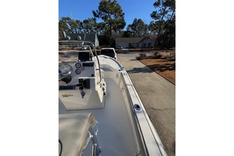 Slide: The Image of 2021 Key West 188 Bay Reef boat interior with rod holders and seating, parked in driveway. - 16