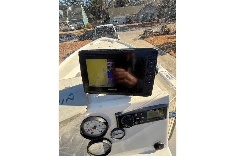 Slide: The Image of 2021 Key West 188 Bay Reef boat interior with console and seating, parked in driveway. - 17