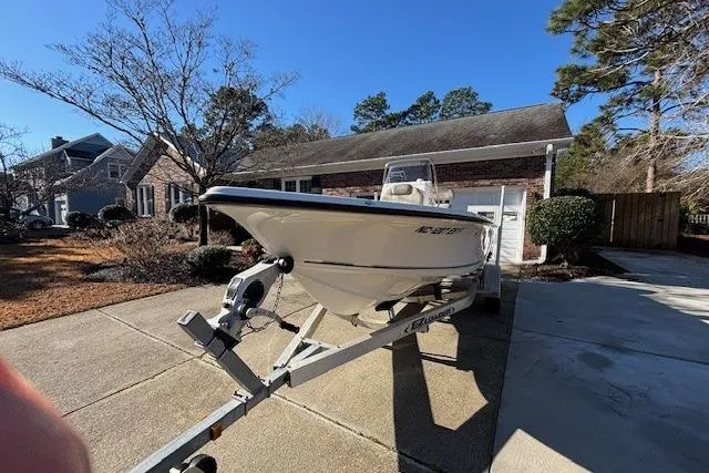 Slide: The Image of 2021 Key West 188 Bay Reef boat on trailer in driveway, surrounded by trees. - 2