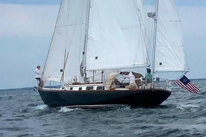 The Image of 1981 Bristol 40 sailboat with American flag sailing on open water. - 0