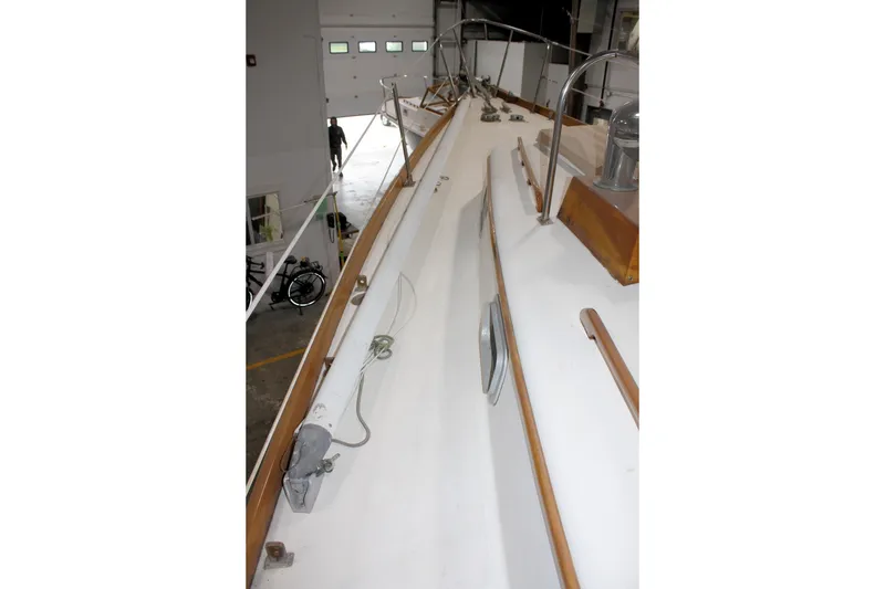 Slide: The Image of 1981 Bristol 40 sailboat deck in a garage, showcasing wooden trim and fittings. - 18