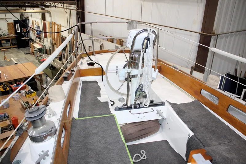 Slide: The Image of 1981 Bristol 40 sailboat interior in a workshop, showcasing steering wheel and deck details. - 22