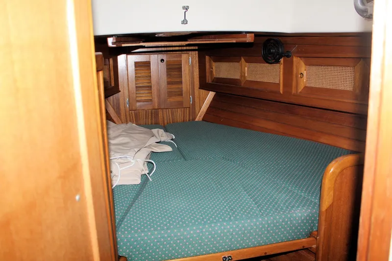 Slide: The Image of Cozy cabin interior of 1981 Bristol 40 sailboat with wooden furnishings and green bedding. - 27