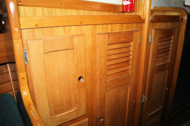Slide: The Image of Wooden interior cabinetry of a 1981 Bristol 40 sailboat, featuring louvered doors. - 31