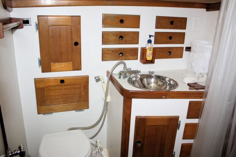 Slide: The Image of 1981 Bristol 40 yacht bathroom with wooden cabinets, stainless steel sink, and toiletries. - 33
