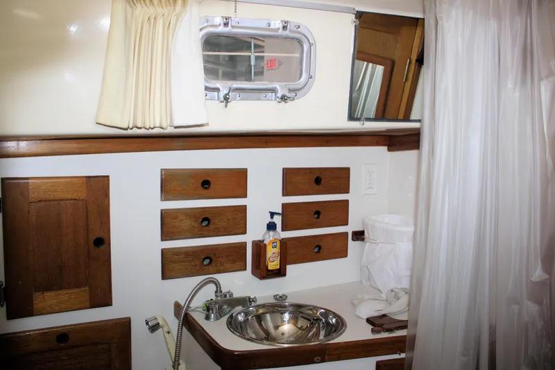 Slide: The Image of 1981 Bristol 40 yacht bathroom with wooden cabinets, stainless steel sink, and nautical decor. - 34
