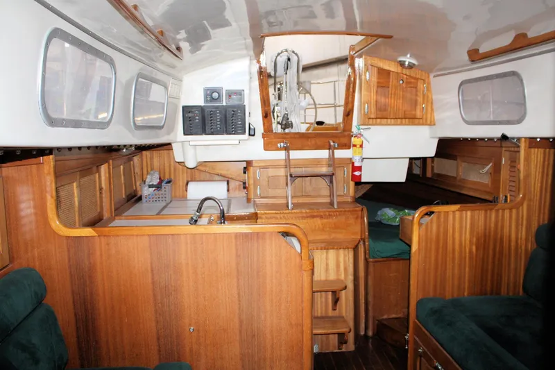 Slide: The Image of Interior of a 1981 Bristol 40 sailboat, featuring wooden cabinetry and seating. - 37