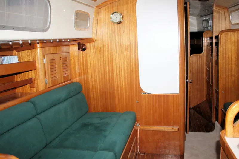 Slide: The Image of Interior of a 1981 Bristol 40 sailboat with wooden paneling and green seating. - 38