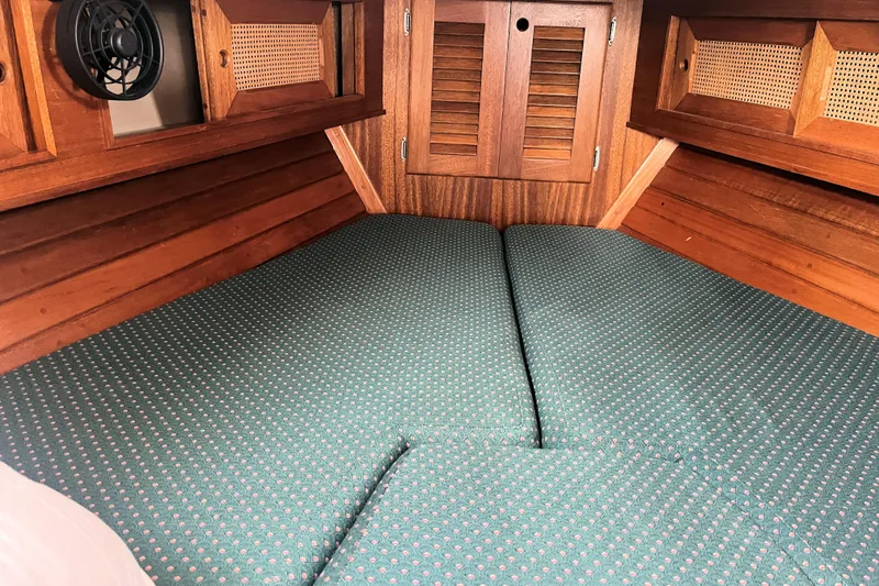 Slide: The Image of Cozy cabin interior of 1981 Bristol 40 sailboat with wooden finish and green cushions. - 4