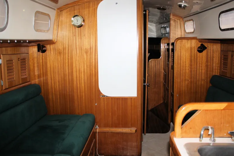 Slide: The Image of Interior of a 1981 Bristol 40 sailboat with wooden paneling and green seating. - 43