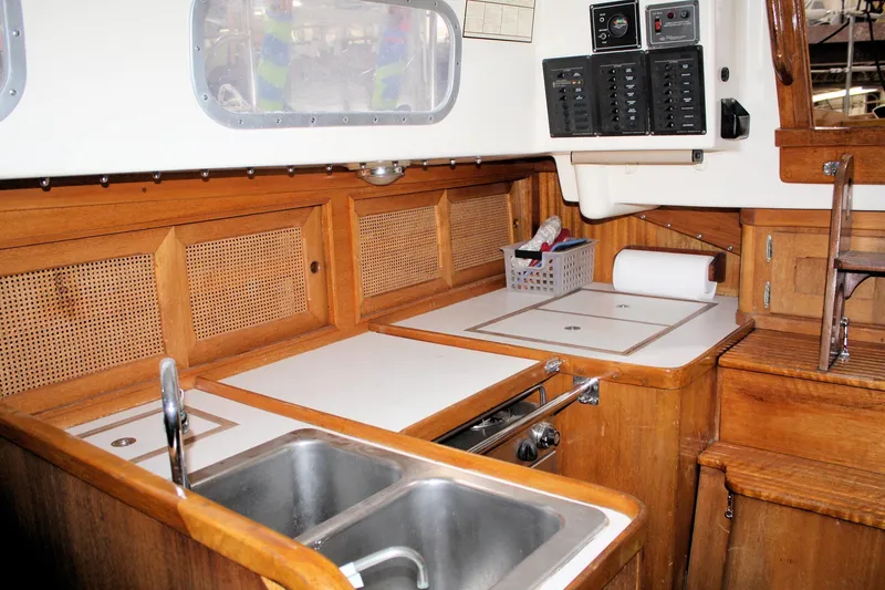 Slide: The Image of 1981 Bristol 40 yacht interior kitchen with wooden cabinetry and stainless steel sink. - 48