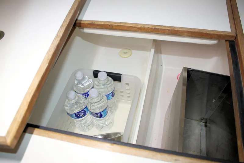 Slide: The Image of Open storage compartment with bottled water inside a 1981 Bristol 40 boat. - 51