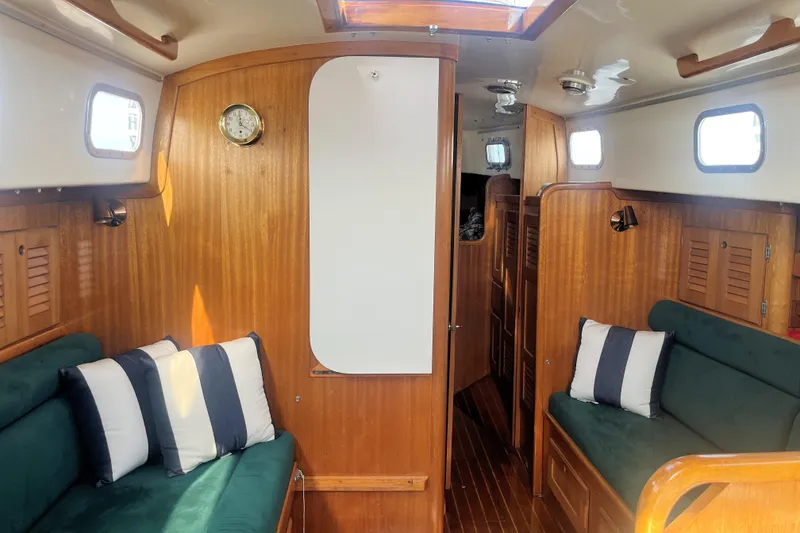Slide: The Image of Interior of a 1981 Bristol 40 sailboat with wood paneling and green seating. - 6
