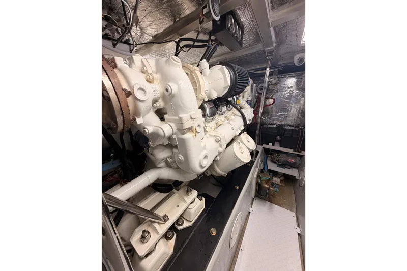 Slide: The Image of Engine room of 1999 Carver 530 Voyager Pilothouse with white machinery and metallic surroundings. - 114