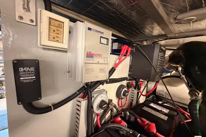 Slide: The Image of Electrical system inside 1999 Carver 530 Voyager Pilothouse, featuring chargers and control units. - 127