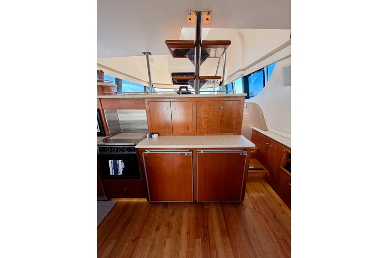 Slide: The Image of Interior of 1999 Carver 530 Voyager Pilothouse with wooden cabinetry and modern appliances. - 29