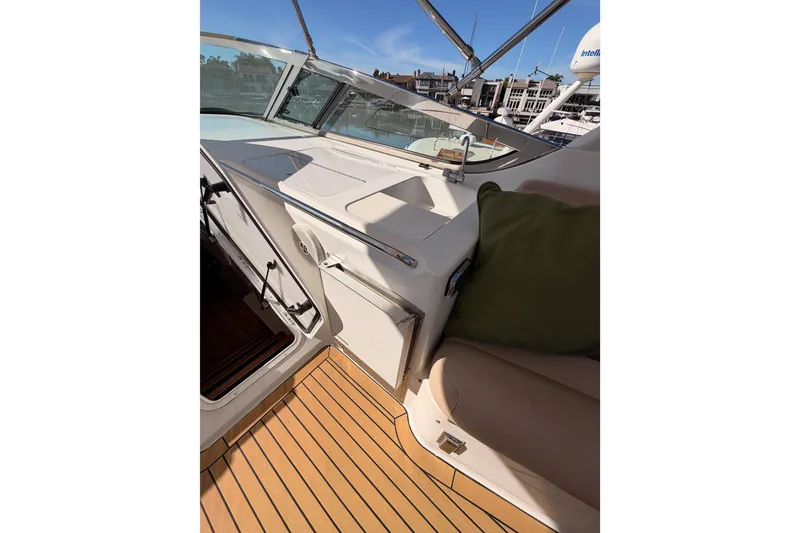 Slide: The Image of 1999 Carver 530 Voyager Pilothouse interior with seating, wooden flooring, and marina view. - 58