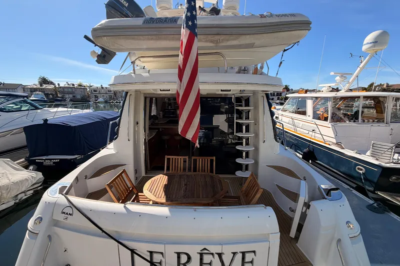 Slide: The Image of 1999 Carver 530 Voyager Pilothouse yacht docked, featuring outdoor seating and American flag. - 6
