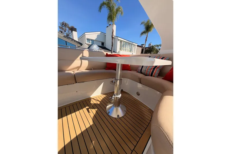 Slide: The Image of 1999 Carver 530 Voyager Pilothouse interior with cushioned seating and table, featuring striped pillows. - 61