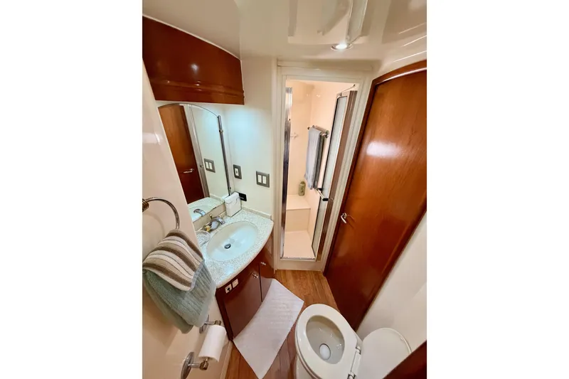 Slide: The Image of Bathroom interior of 1999 Carver 530 Voyager Pilothouse yacht, featuring sink, toilet, and shower. - 84