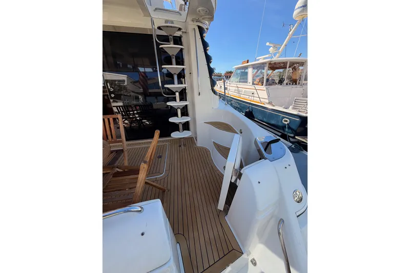 Slide: The Image of 1999 Carver 530 Voyager Pilothouse yacht deck with wooden flooring and spiral staircase. - 10