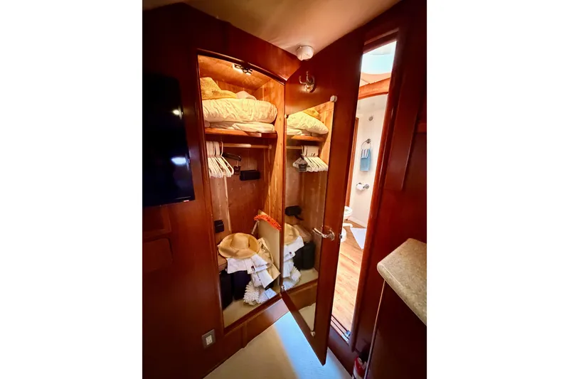 Slide: The Image of Interior of 1999 Carver 530 Voyager Pilothouse showing a wooden closet with clothes and accessories. - 101